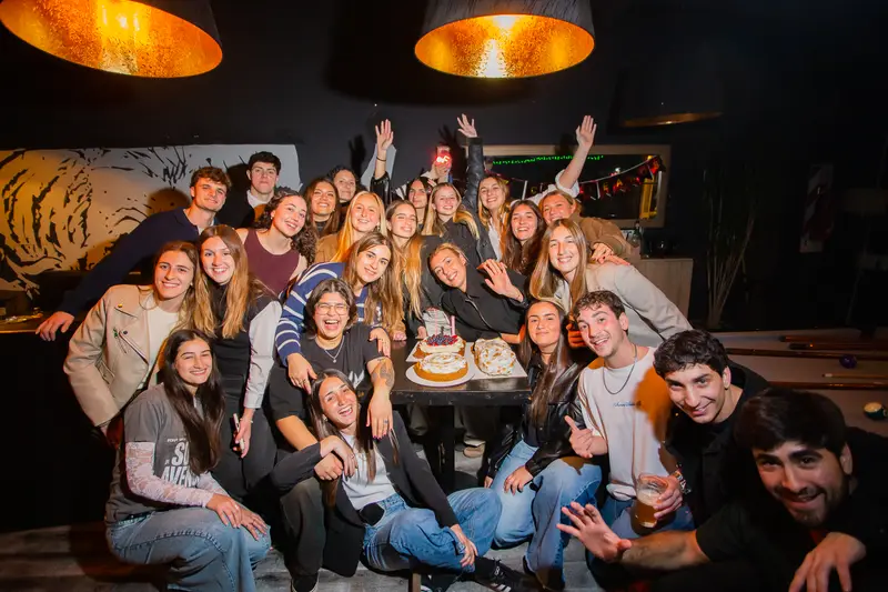 Un grupo grande festejando un cumpleaños en Fauno con torta