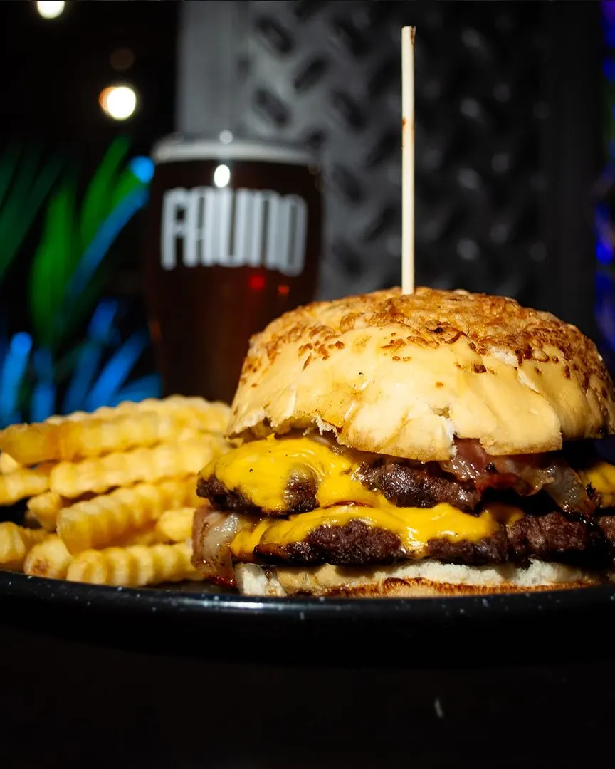 Una hamburguesa doble con cheddar, papas y una pinta