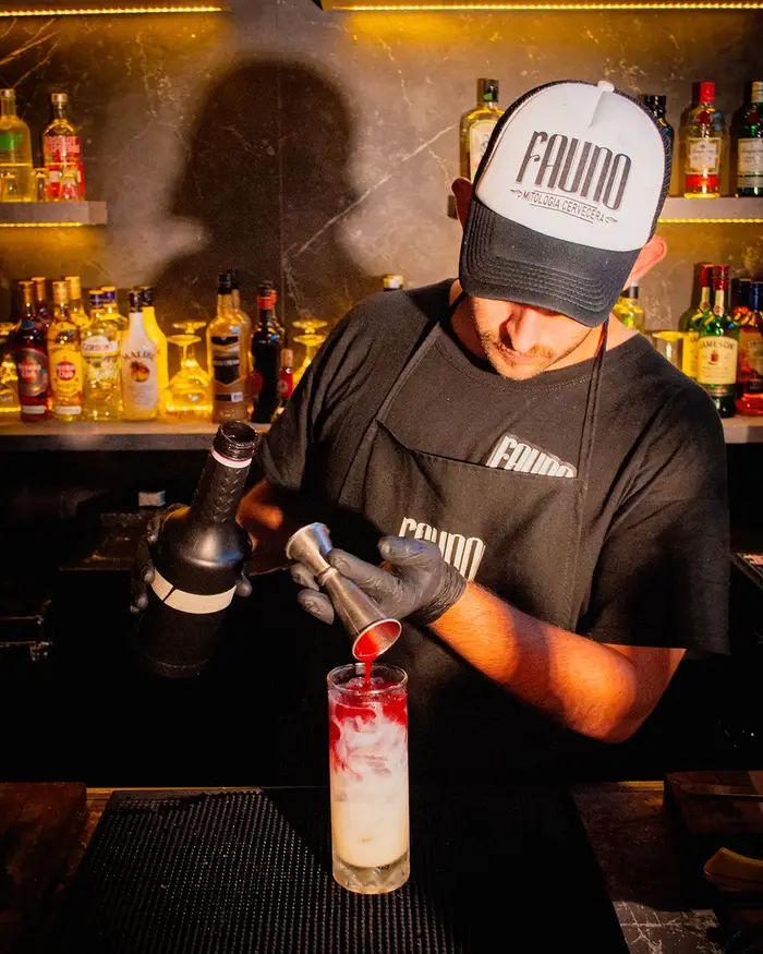 El bartender sirviendo un trago en la barra