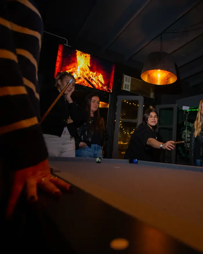 Partido de pool con la chimenea de fondo