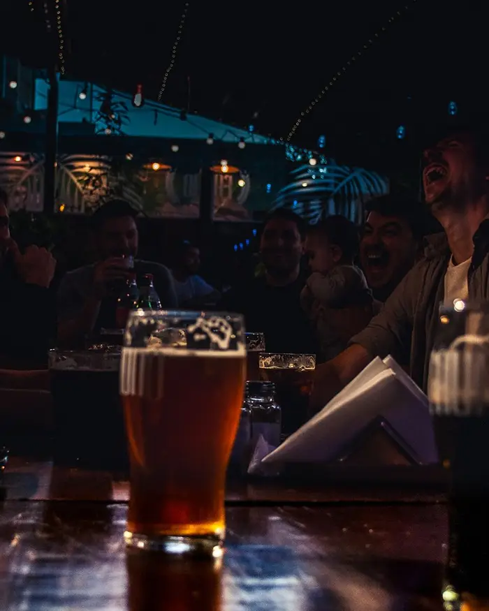 Amigos en la mesa con una pinta en primer plano