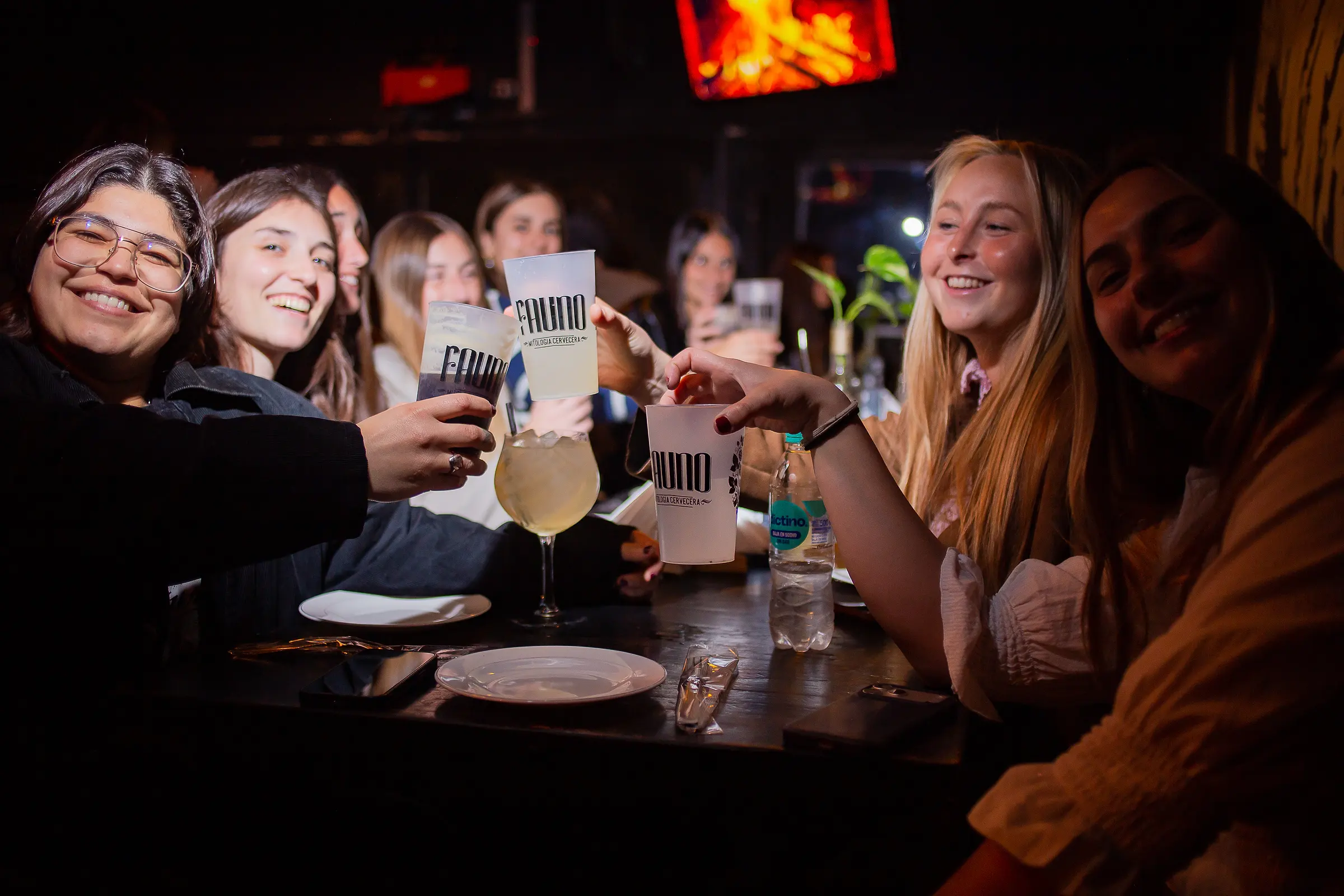Amigas brindando en Fauno con los vasos del bar